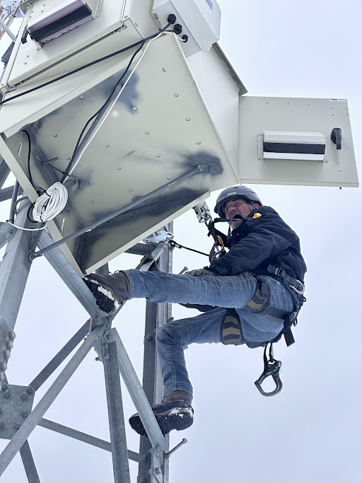 Shawn Graham climbing communications infrastructure